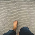 un homme pieds nus dans le sable